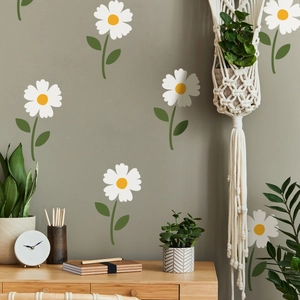 Detailed view of white daisy wall stickers on a muted green wall in a home office setup