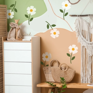 Detail of white daisy wall stickers with green leaves on a cream and earthy background