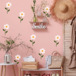 Detail of white daisy wall stickers applied on a pink wall in a minimalist nursery setting