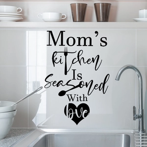 Dettaglio dell'adesivo murale Mom's Kitchen in vinile nero con motivi di cuori e utensili su piastrelle