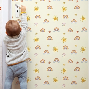 Hand-drawn sun and rainbow wall stickers in a warm-toned cozy nursery setting