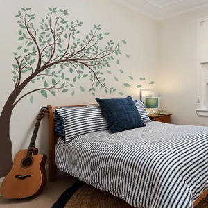 Detail of green leaf tree wall decal in a bedroom setting with realistic textures