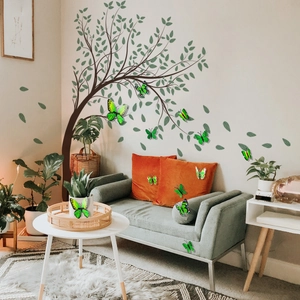 Nature wall sticker featuring a brown tree with green leaves and yellow butterflies over a sofa