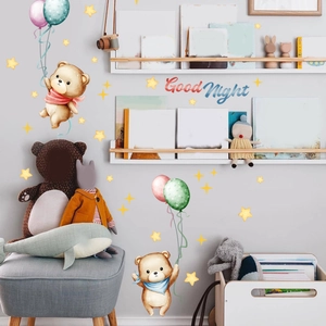 Détail des stickers muraux ours et étoiles fluorescents dans une chambre d'enfant douce