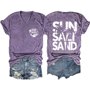 Flat lay of purple V-neck t-shirt with Sun Salt Sand print and distressed denim shorts