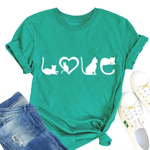 T-shirt vert avec imprimé chat et cœur, présenté avec un jean bleu et baskets blanches