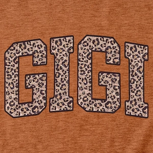 Gros plan du lettrage GIGI à motif léopard sur le tissu d'un t-shirt marron d'été