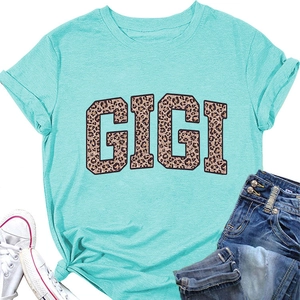Gros plan du lettrage GIGI léopard sur t-shirt turquoise avec nœud à l'ourlet