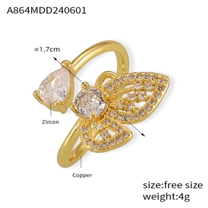 Détail de la bague papillon dorée avec gouttes de zircon et anneau en cuivre