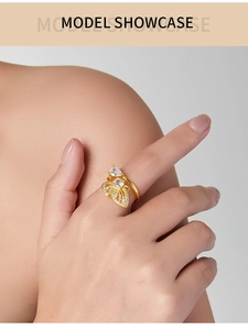 Détails d'une bague papillon dorée avec zircon en forme de goutte portée par un mannequin