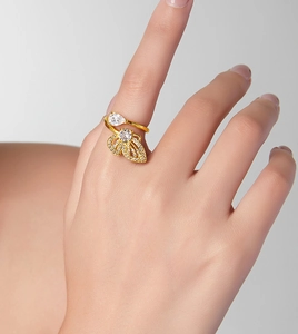 Gros plan d'une bague papillon dorée ornée de zircons sur le doigt d'une femme