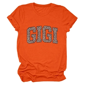 Detalle de las mangas enrolladas y el estampado GIGI de leopardo en la camiseta naranja