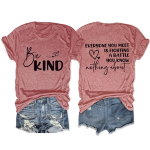 Détail d'un t-shirt rouge rétro avec imprimé Be Kind et short en jean vieilli