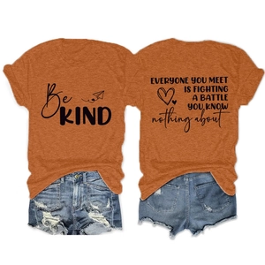 Détail d'un t-shirt orange imprimé Be KIND et d'un ensemble de shorts en jean