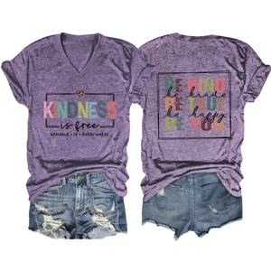 Detail of purple V-neck T-shirt showing BE KIND print and distressed denim shorts