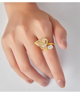 Vue détaillée d'une bague papillon dorée avec zircons et une pierre en forme de poire