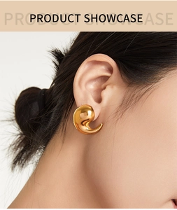 Gros plan de boucles d'oreilles virgule minimalistes plaquées or 18 carats