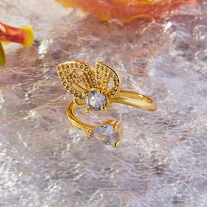 Bague papillon dorée avec des pierres de zircon blanc sur fond de cristal luxueux