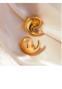 Détail macro de boucles d'oreilles virgule en plaqué or 18K sur tissu en soie beige