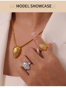 Detailed view of North Star pearl necklace and rings on model in white blazer
