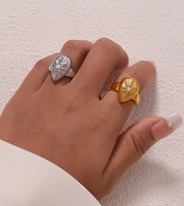 Macro shot of retro gold and silver teardrop rings with center pearls and diamonds