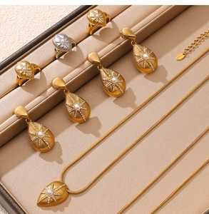 Detail of starburst pendant set with pearl and zircon inlay in a brown jewelry box
