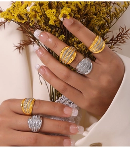 Close-up of wide multi-layer pavé crystal rings in gold and silver plating