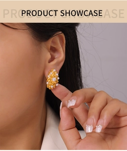 Detail of gold geometric pearl stud earring with hammered texture on a model's ear