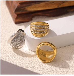 Close-up of wide multi-layer rings with shimmering pavé diamonds in gold and silver