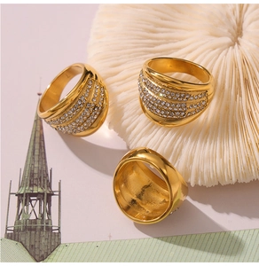 Macro view of three gold-plated wide band rings with multi-layer pavé crystal settings
