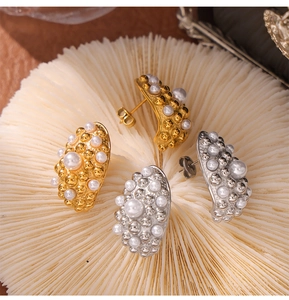 Detailed close-up of vintage geometric shell pearl earrings with textured gold and silver finish