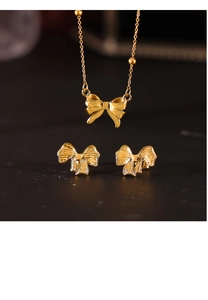 Detailansicht eines goldenen Schleifen-Schmucksets mit strukturiertem Anhänger und Ohrringen