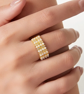 Detail of wide 18K gold plated ring featuring four rows of pearls and sparkling crystals
