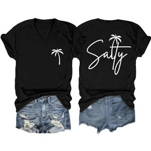 Flat lay view of black V-neck T-shirt with palm tree print and distressed denim shorts