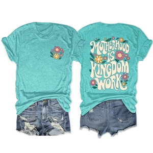 Close-up of mint green t-shirt back with floral art and Motherhood is Kingdom text