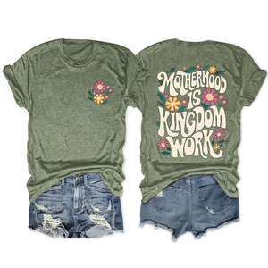 Detailed flat lay of a green floral t-shirt with Motherhood Is Kingdom back graphic print