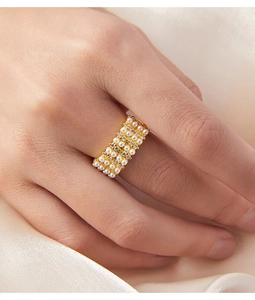 Detail of 18K gold plated wide ring with four rows of pearls and crystals on hand
