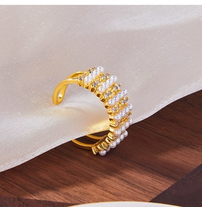 Detailed view of 18K gold plated wide ring featuring five rows of pearls and small crystals