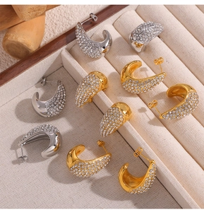 Détail de boucles d'oreilles créoles pavées en or et argent avec zircons étincelants