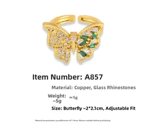 Detalle macro de un anillo mariposa chapado en oro 18k con gemas verdes y brillantes