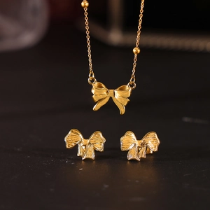 Elegantes Schmuckset mit Schleifenanhänger und Ohrringen aus goldfarbenem Titanstahl