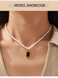 Detail of freshwater pearl necklace with zircon-framed black pendant on model's neck