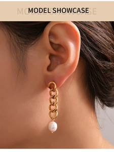 Close-up of a gold chain tassel earring with a white freshwater pearl on model