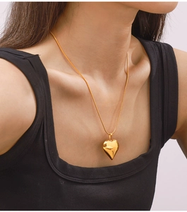 Detail of 18k gold plated hollow heart pendant necklace worn on a female model