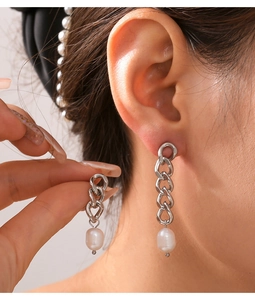 Detail of silver chain tassel earrings with white freshwater pearls on a model