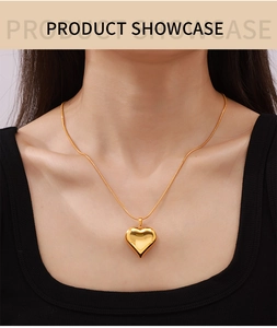 Detail of 18k gold plated hollow heart pendant with sleek snake chain on a model