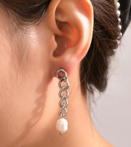 Close-up of silver Cuban chain drop earrings with a natural white freshwater pearl