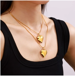 Close-up of double-layered 18k gold plated heart pendant necklace with polished surface
