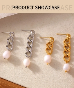 Detailed view of gold and silver chain drop earrings with white freshwater pearls