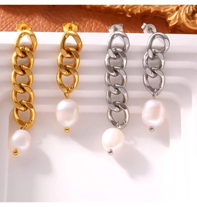 Detail of gold and silver chain drop earrings with freshwater pearls on a white stand